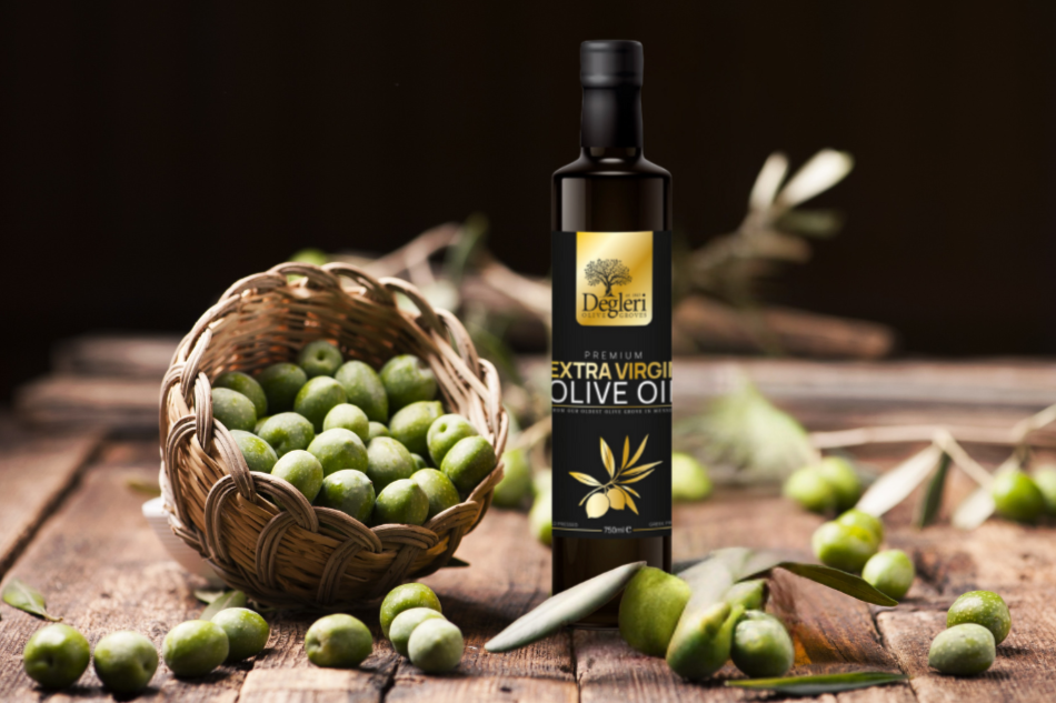 Degleri Premium Extra Virgin Olive Oil bottle with fresh green olives in a woven basket on rustic wooden table, highlighting Greek single-origin harvest