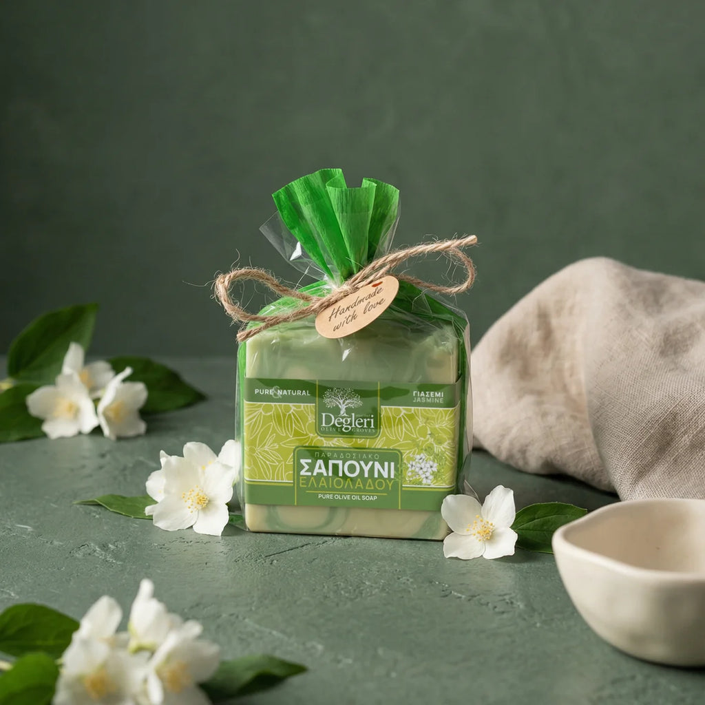 Degleri jasmine pure olive oil soap gift-wrapped in green organza with twine bow, surrounded by fresh white jasmine flowers — handmade in Greece